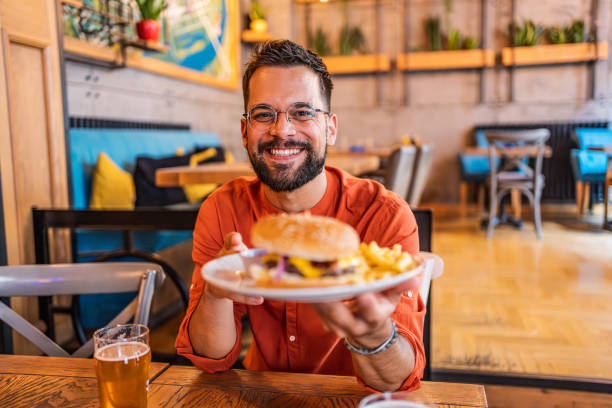 istock Young man holding a plate with a tasty burger 2183714657