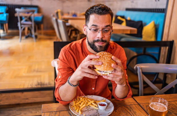 istock Young man enjoying a delicious burger 2183714705