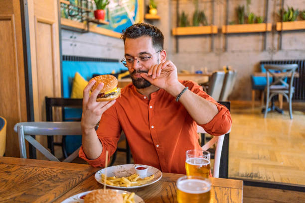 istock Young man enjoying a delicious burger 2183714934