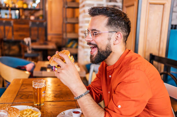 istock Young man eating a delicious burger 2183715010
