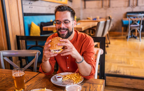 istock Young man eating a delicious burger 2183715193