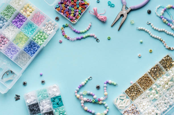 istock Colorful assortment of beads and jewelry-making tools on a blue surface with completed bracelets 2183716187