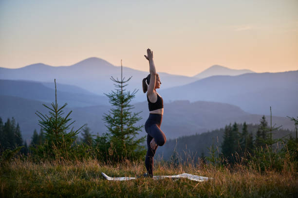 istock Woman practicing yoga outdoors in the mountains in a serene, natural setting. 2183716645