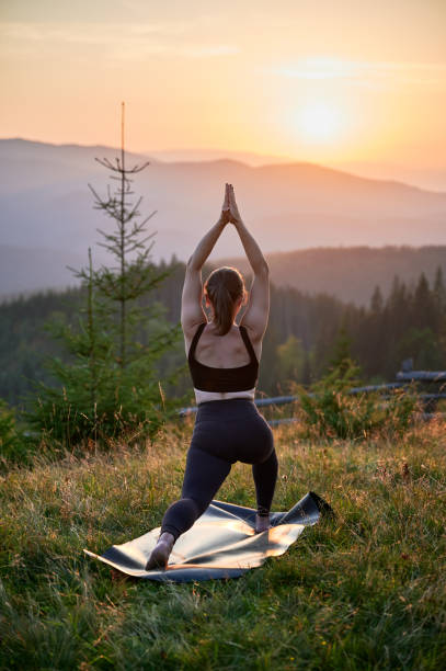 istock Woman practicing yoga outdoors in the mountains in a serene, natural setting. 2183716648
