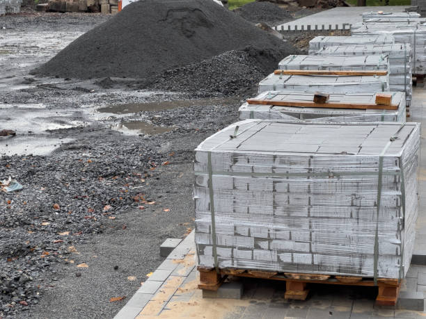 istock Crates stacked high with gray concrete blocks are neatly arranged on pallets, ready for use in construction at a bustling site in the early hours of the day 2183716890