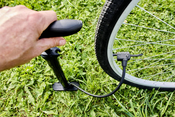 istock Inflating bicycle tire using floor pump with presta and schrader valve adaptor. 2183717296