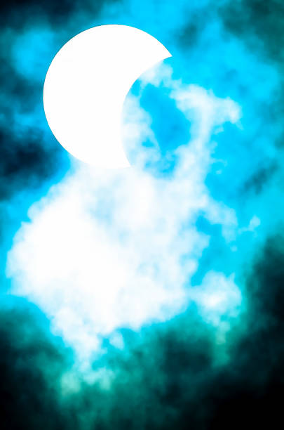A blue sky with a white moon in the middle. The sky is filled with clouds and the moon is the only white object in the scene