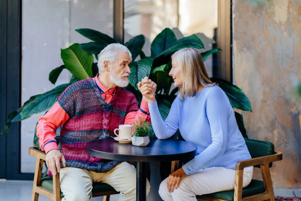 istock Elderly couple enjoying a warm conversation at a cozy cafe interior. 2183718933