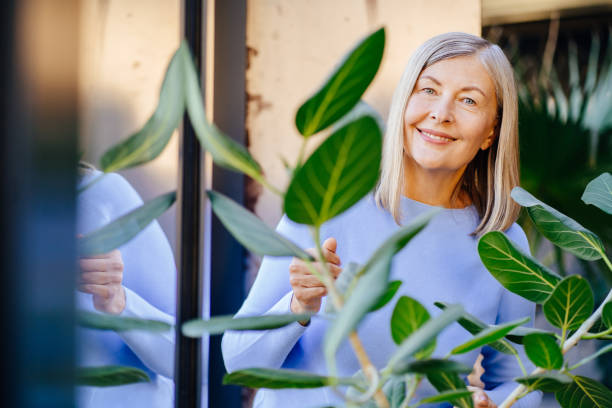 istock Smiling elderly woman enjoying time with indoor plants 2183718945