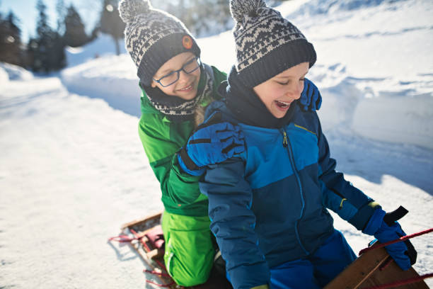 Full Length Of Girl Tobogganing On Snow Covered Field
