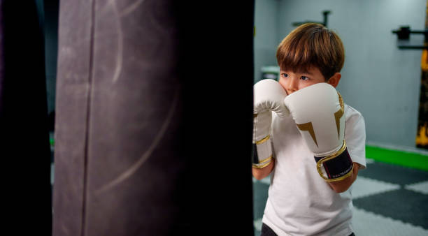 istock child athlete training on a punching bag in a gym. 2183726251