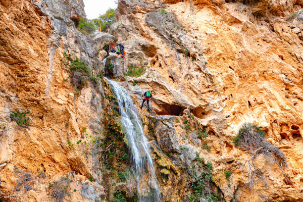 A stunning waterfall flows down rugged cliffs adorned with vibrant greenery, creating a peaceful natural setting.