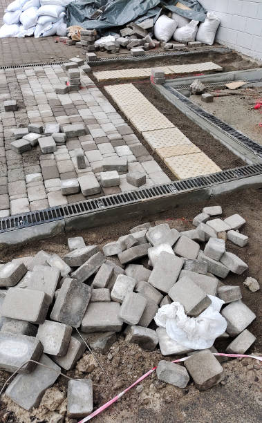 istock Construction of a tiled stone pavement with drainage ebb. Infrastructure construction site 2183729603