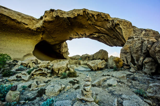 istock A large rock archway with a small opening in the middle 2183729818
