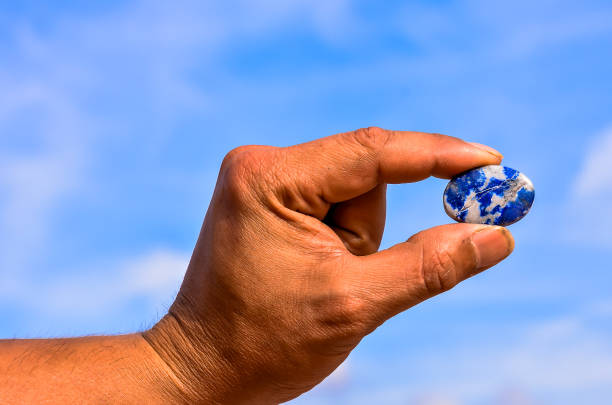 istock A hand holding a blue and white stone 2183729905