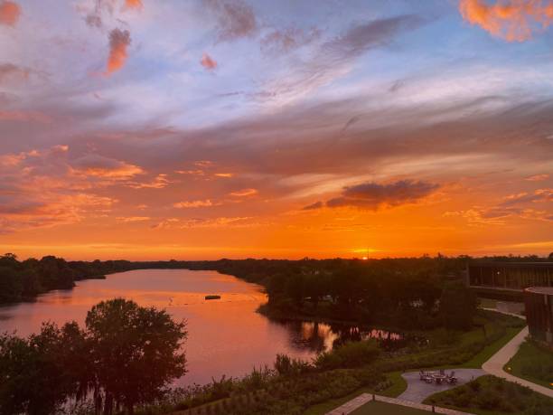 istock Vibrant sky at sunset over a serene river and green trees 2183729915