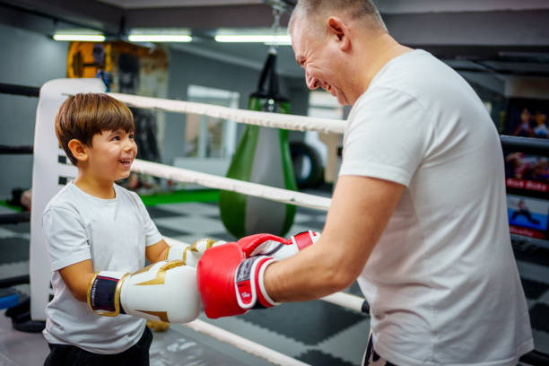 istock Father and son bonding through boxing training in a gym. 2183732458