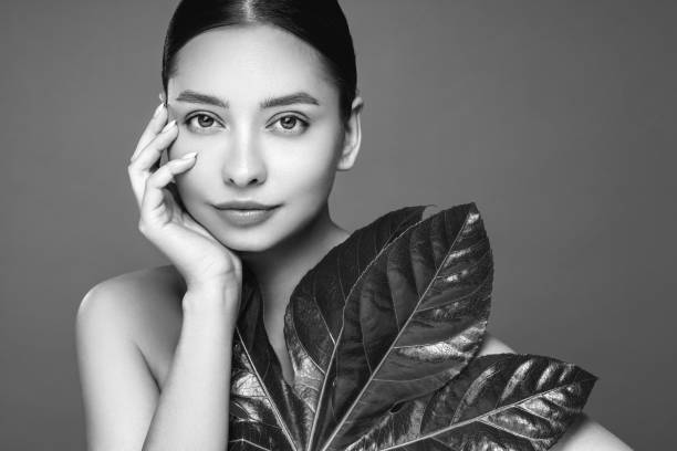 istock Close up woman face with green exotic leaf 2183733890