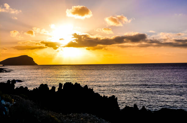 istock The sun is setting over the ocean, casting a warm glow over the water 2183737048