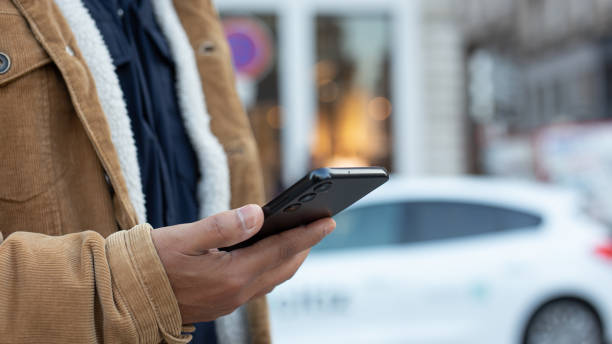 istock Man using smartphone app for renting electric car sharing service 2183739837