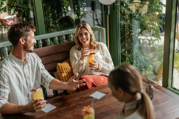 istock Three people sitting in a cozy cafe decorated by greenery 2183741375