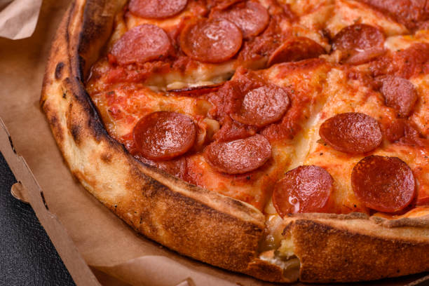 istock Pepperoni pizza with sausage, mozzarella cheese, tomatoes, salt and spices 2183744116