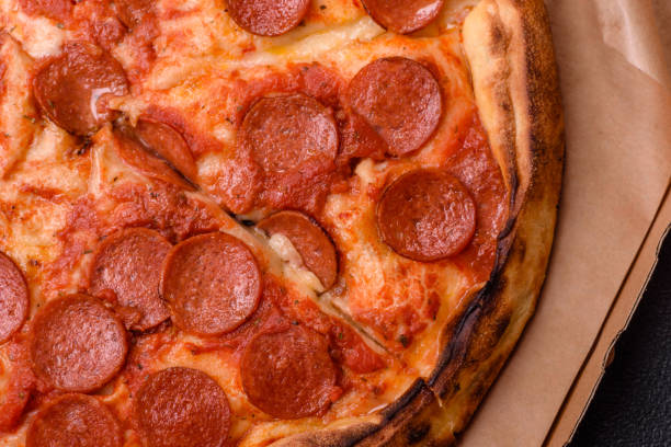 istock Pepperoni pizza with sausage, mozzarella cheese, tomatoes, salt and spices 2183744120