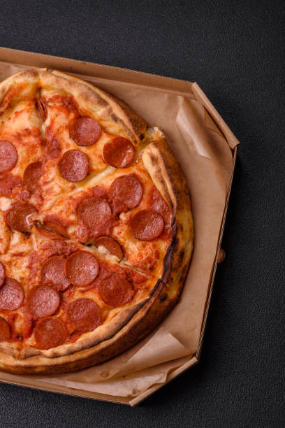 istock Pepperoni pizza with sausage, mozzarella cheese, tomatoes, salt and spices 2183744128