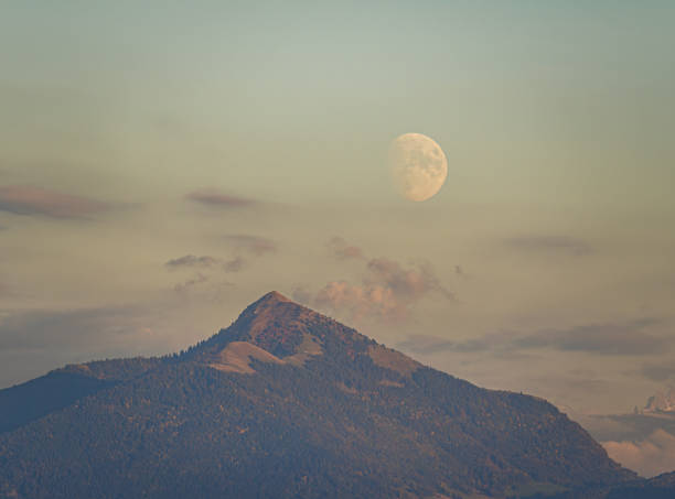 The nearly full moon rising behind Le Mole in France, at sunset over the Alpine foothills