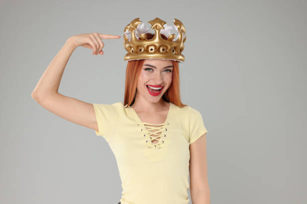 istock Beautiful young woman with inflatable crown on light grey background 2183746929
