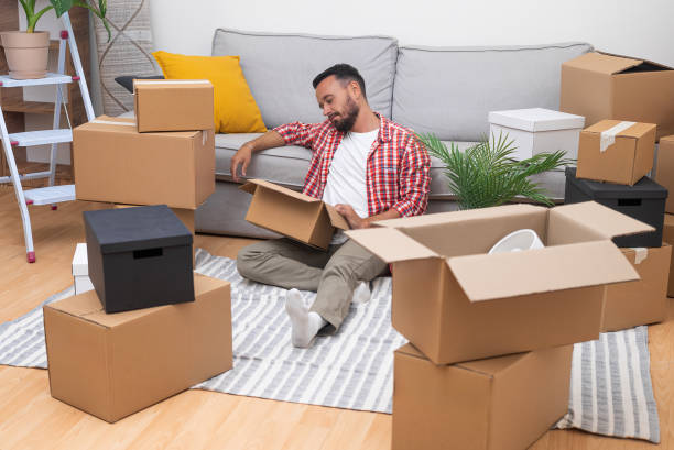 istock moving home young man unboxes his possessions, relocation, whether for rentals or home ownership 2183752252