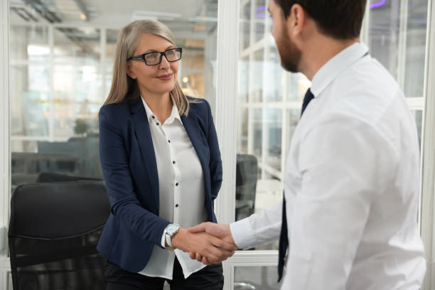 istock Lawyer shaking hands with client in office 2183752910