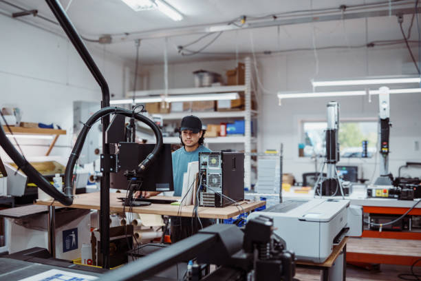 istock Male employee operating large format printer and paper cutter in factory 2183753304
