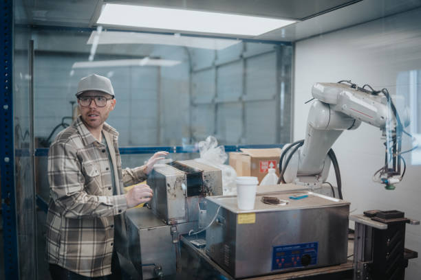 A man operates a robotic arm when working in the manufacturing and fabrication facility his family owns.