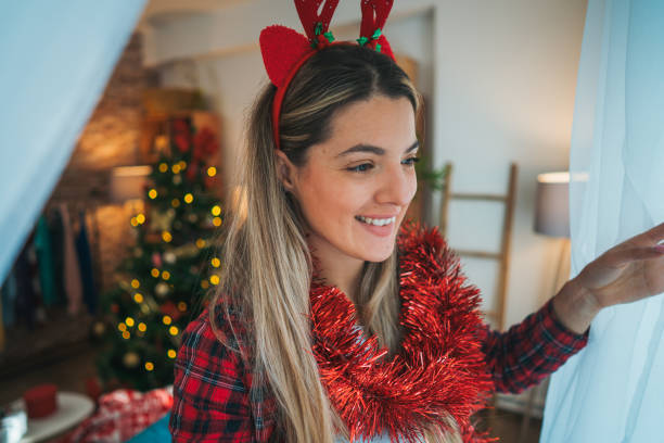 istock Smiling woman by the window at Christmas 2183761433