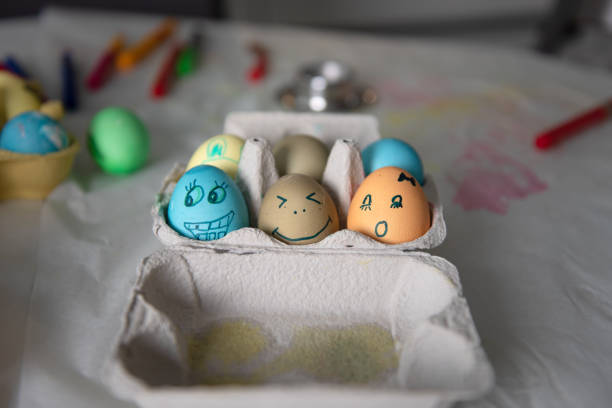 In an egg carton, there are Easter eggs painted with colorful designs.