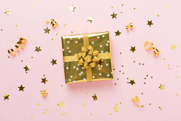 istock Golden gift boxes and confetti on color background, top view 2183766889