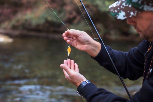 istock Fisherman replaces the bait at river closeup with copy space 2183768151