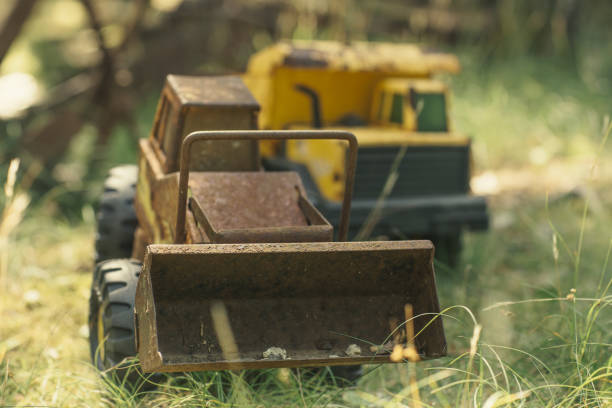 rusted toy bulldozer machine in grass lawn