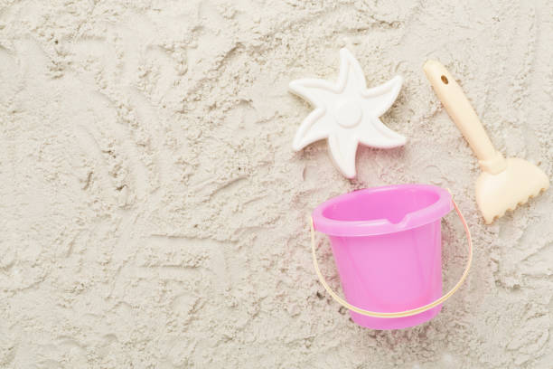 istock Cute toys for playing on sand background, top view 2183773113