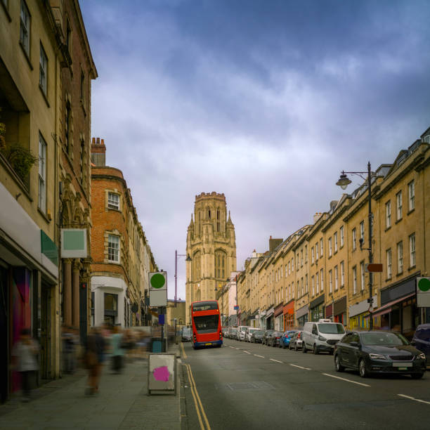 Captivating view of a grand building in bath, england, set against a vibrant blue sky, with a bare tree adding a touch of nature to the urban scene