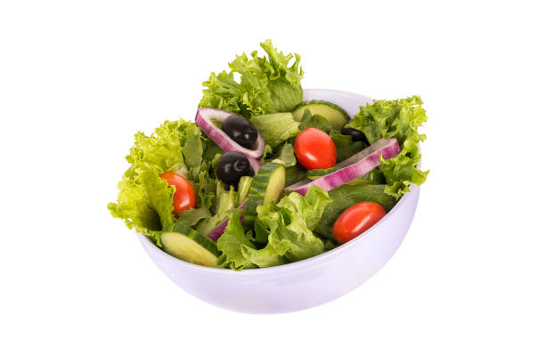 Green lettuce salad with fresh vegetables, isolated on white background. Cut out.