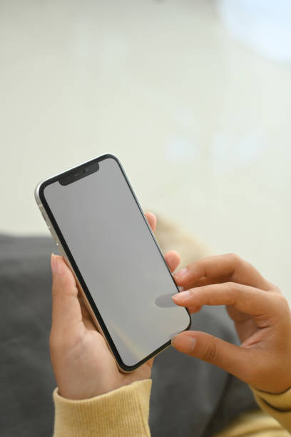 istock Woman hands holding smartphone with white empty screen sitting on sofa 2183790280