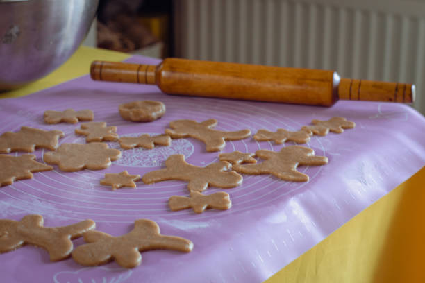 Christmas cookies with rolling pin on the table. Raw gingerbread cookies in Christmas forms. Christmas background. New year treats. Cinnamon biscuits close up. Sweet food background. Xmas pastry.