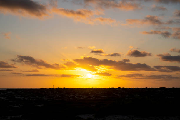 Sunset over rugged coastline and calm sea, Baja