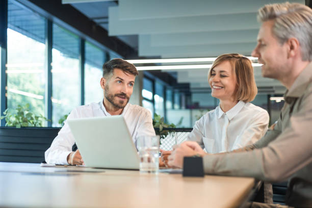istock Three business people discussing work together using a tablet and laptop taking notes in a modern office 2183817192