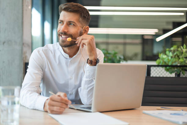 istock Handsome male customer support operator consulting clients with headset and laptop 2183818297