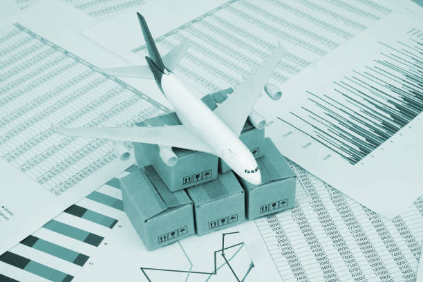 istock Airplane model and shipping carton boxes on financial documents close up. 2183820299