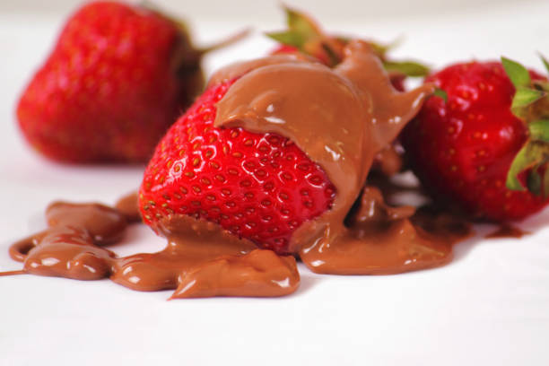 A closeup view of a cup of strawberries and Belgian milk chocolate.