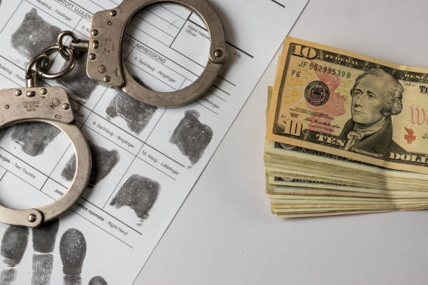 istock American dollar banknotes and fingerprint card, handcuffs 2183825249